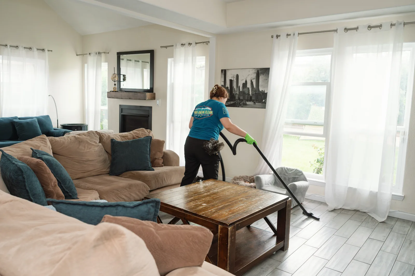 Sandia Green Clean cleaner vacuuming under living room furniture